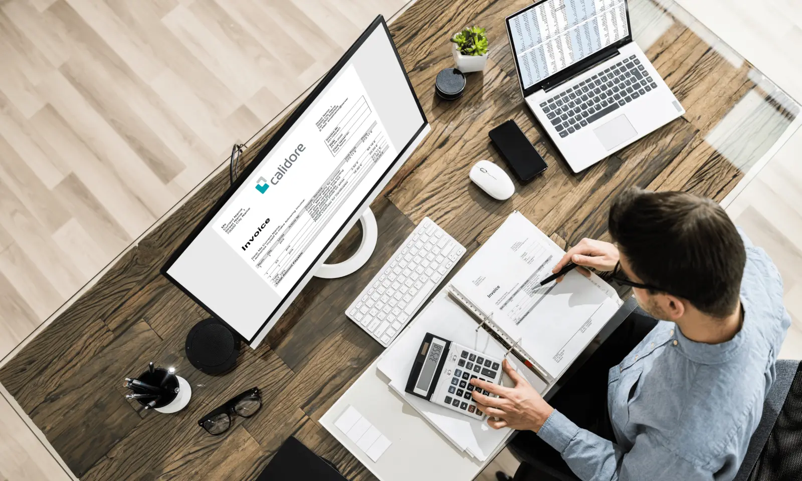 Person working through invoices at a desk, with a Calidore invoice on screen