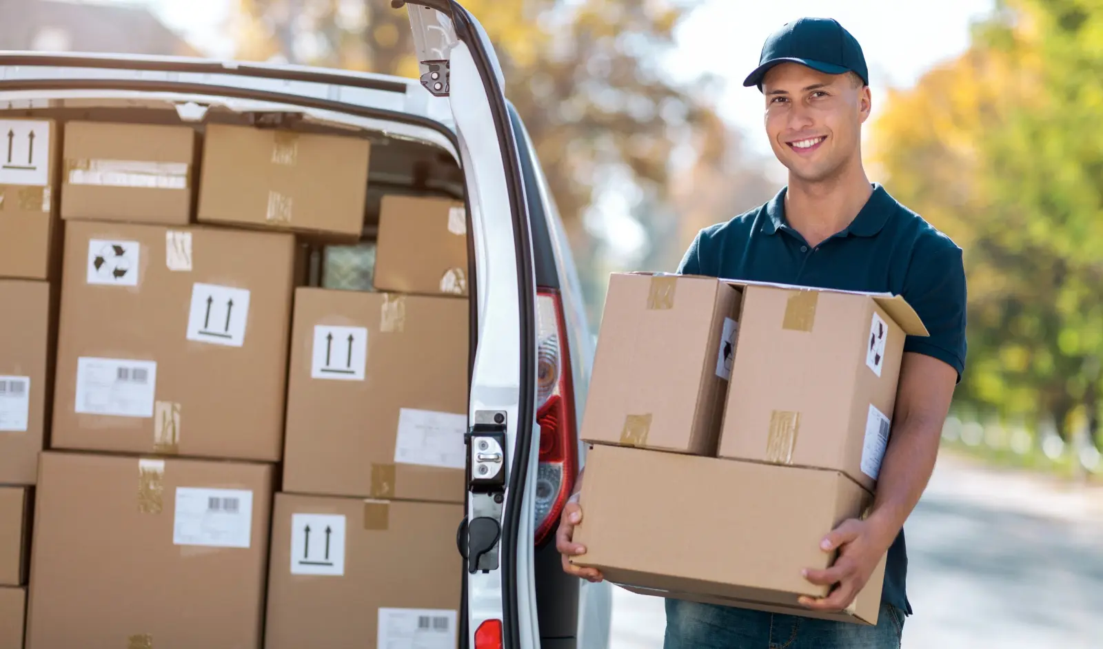 Delivery driver carrying boxes from a van